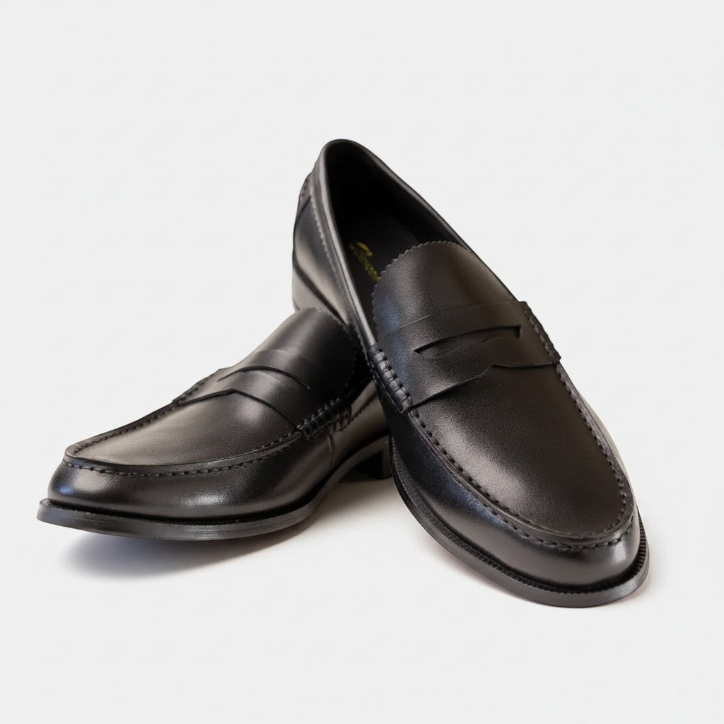 Barcon Getta Inc ABUJA black leather penny loafers with traditional strap detail and sleek silhouette.