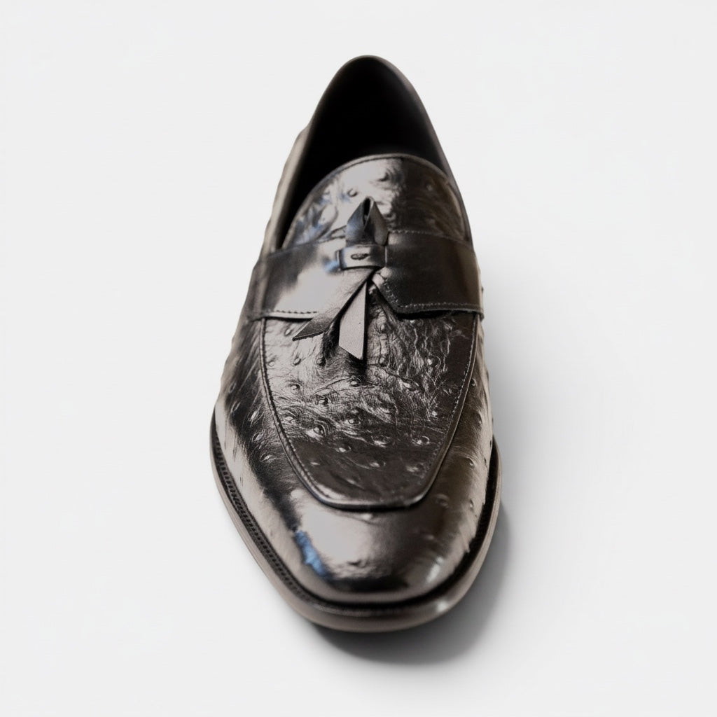 Barcon Getta Inc black ostrich-embossed leather kiltie tassel loafer with pointed toe and stacked heel.