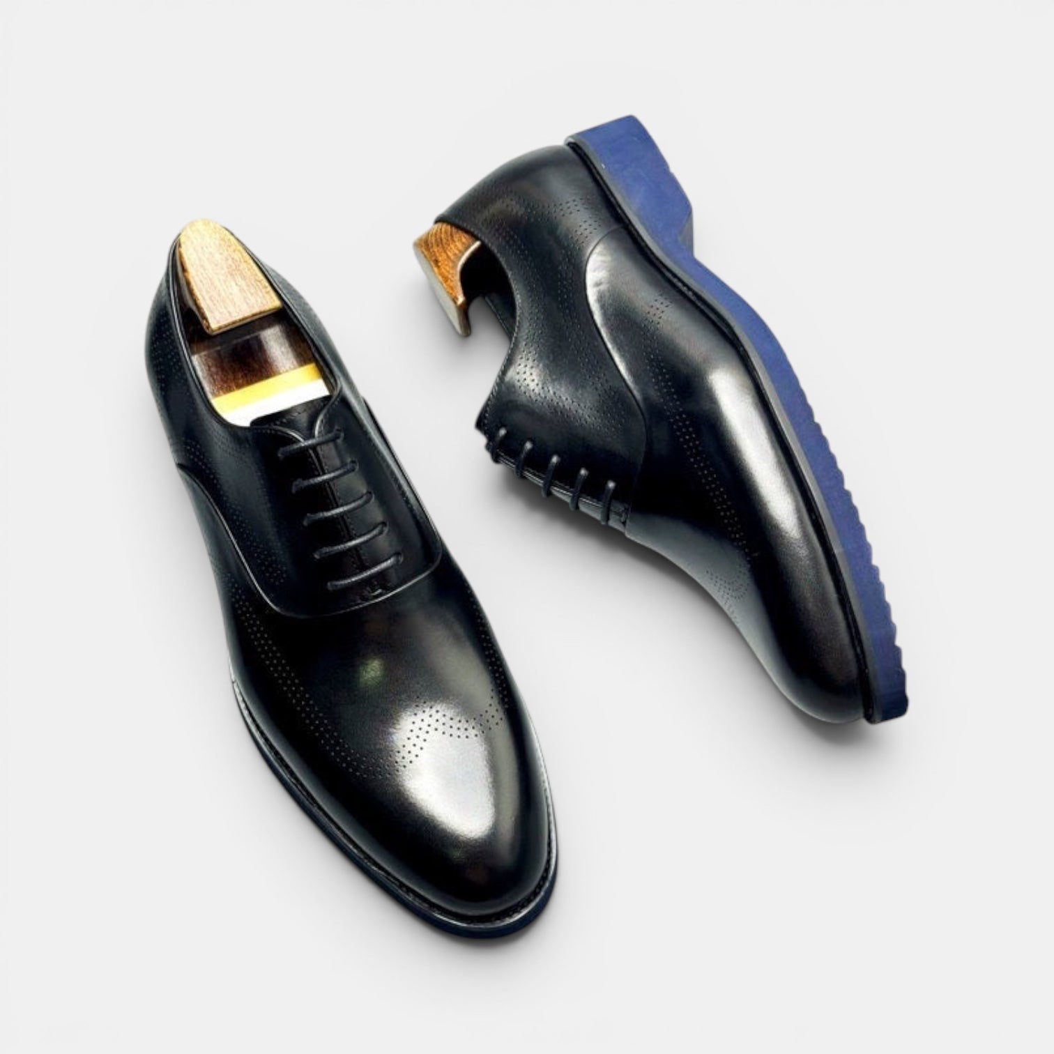 Barcon Getta Inc black leather wingtip brogue Oxford dress shoes with blue soles.
