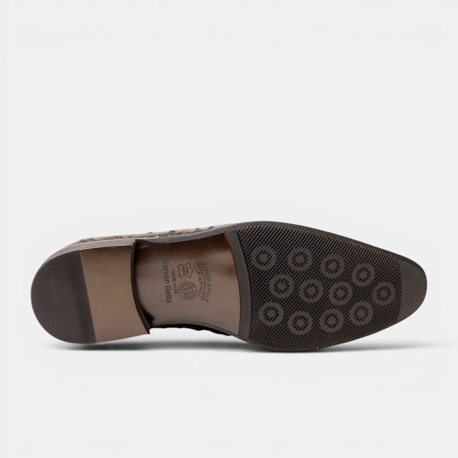 Barcon Getta Inc LILONGWE ostrich embossed leather loafer sole view. Full rubber sole with circular lug pattern heel.