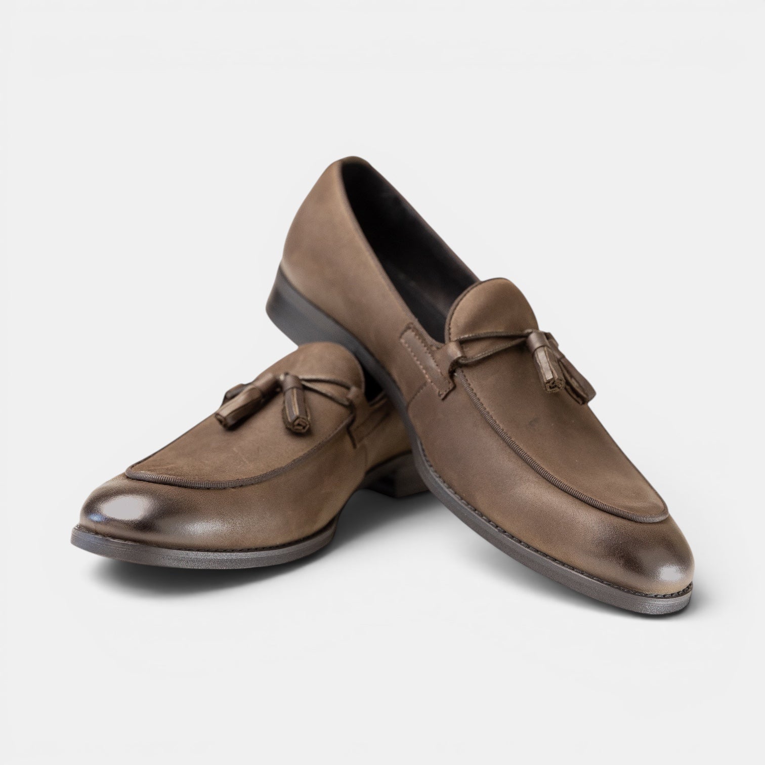 Barcon Getta Inc MANZINI taupe full-grain leather tassel loafers with apron toe and burnished finish.