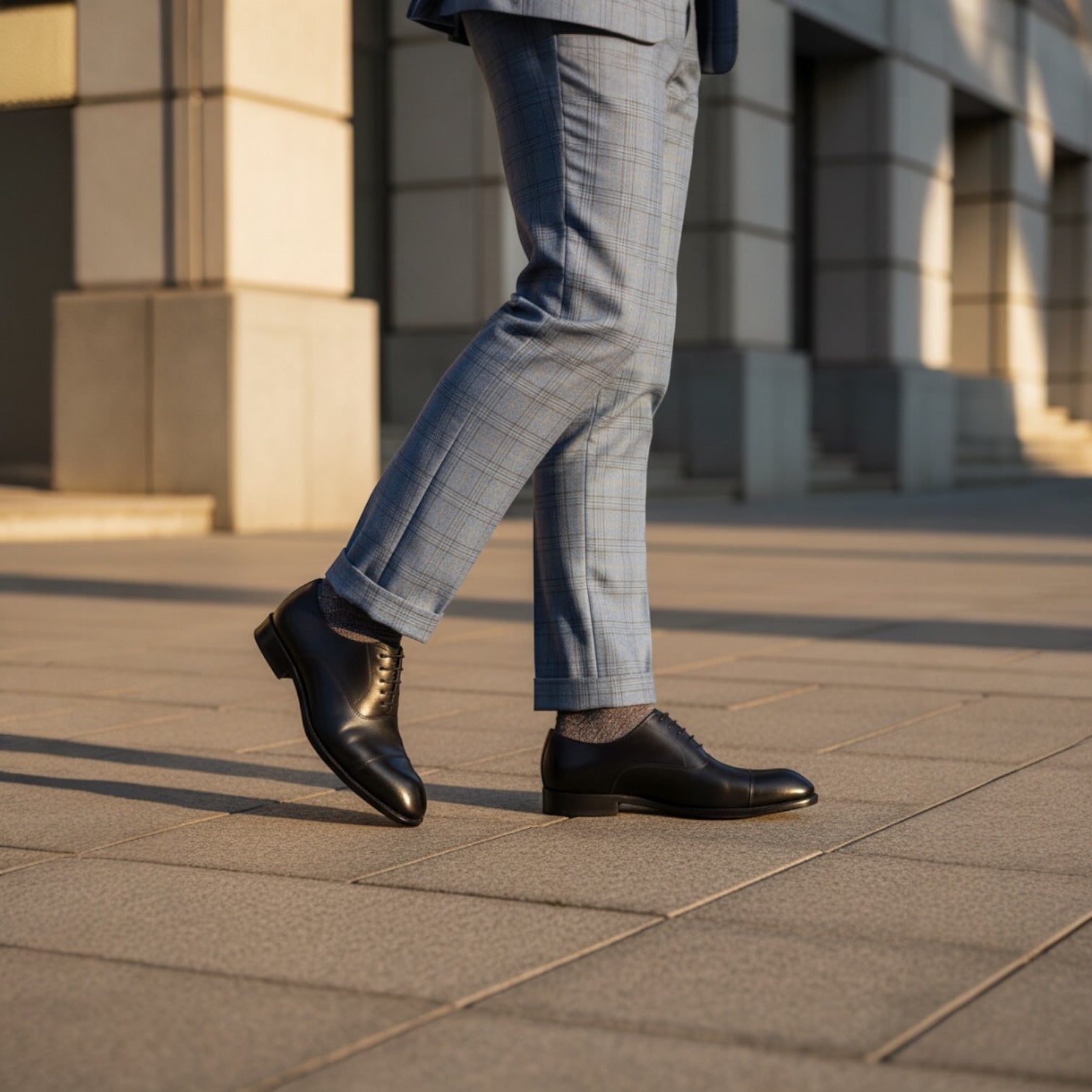 Barcon Getta Inc MOGADISHU CLASS black full grain leather cap toe Oxford dress shoes worn by a man in light blue plaid suit pants.