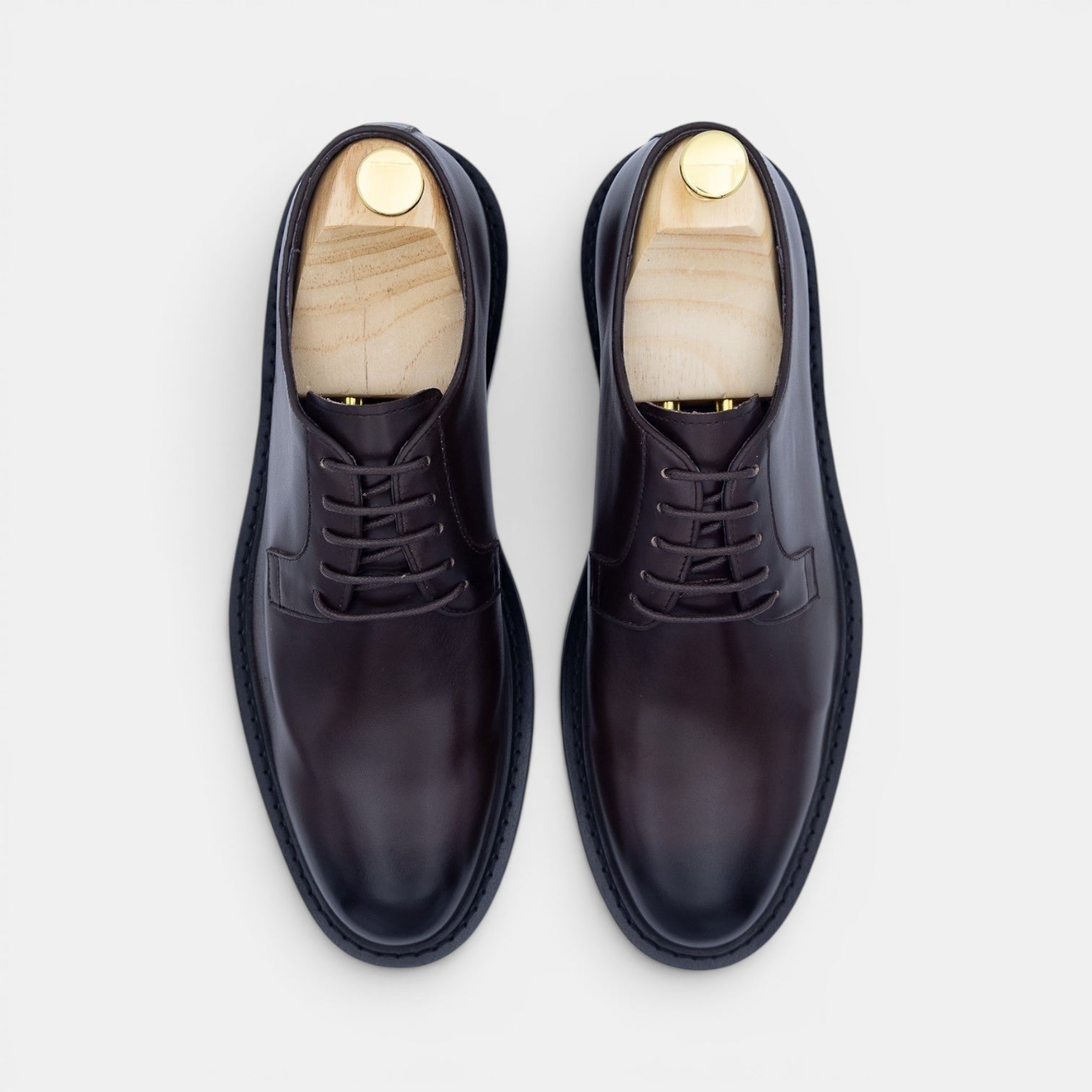 Barcon Getta Inc NYOTA plain toe Derby shoes in dark espresso brown hand-burnished full grain leather with a navy rubber sole.