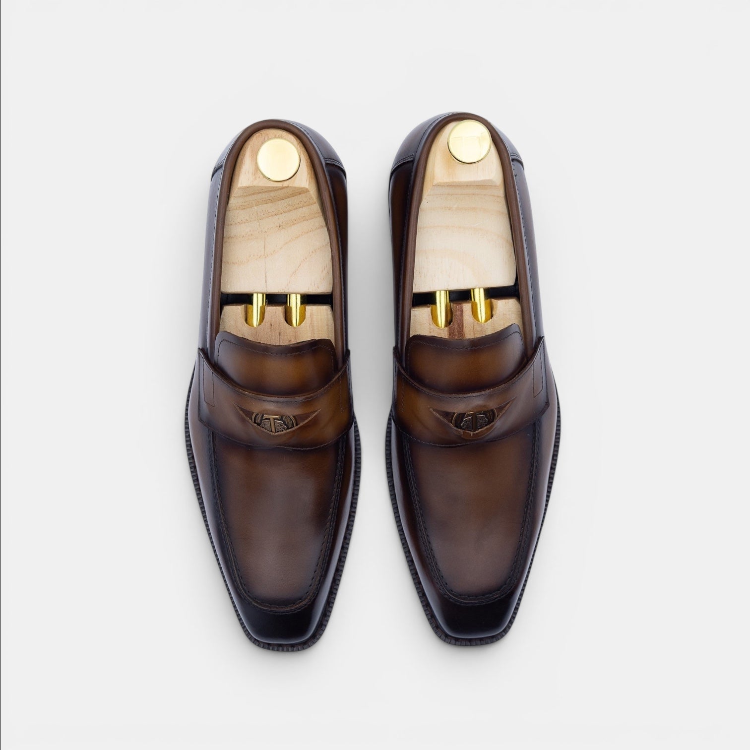Barcon Getta Inc NEGUS brown leather penny loafers with metal accent and wooden shoe trees.