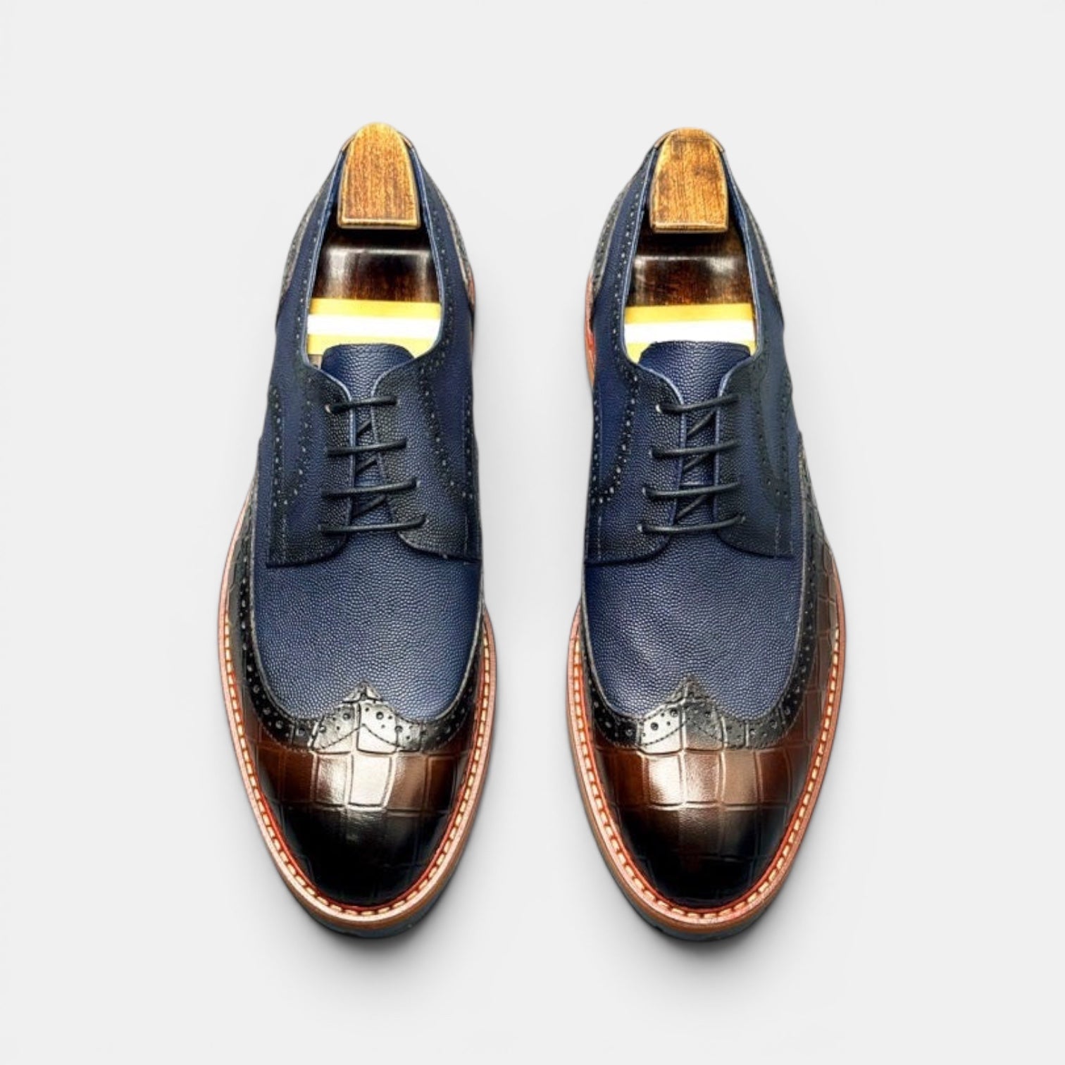 Barcon Getta Inc navy leather wingtip brogues with brown croc-embossed toe and heel.
