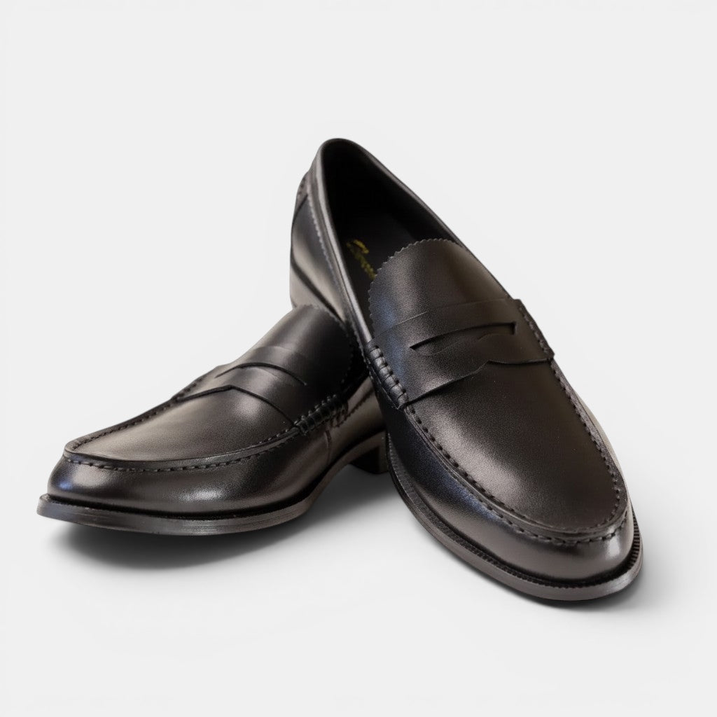 Barcon Getta Inc ABUJA black leather penny loafers with traditional strap detail and sleek silhouette.