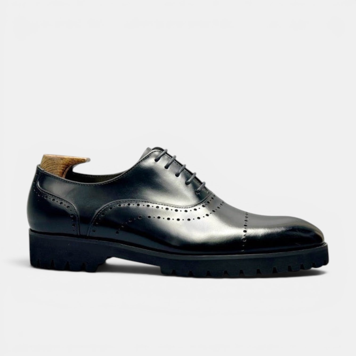 Barcon Getta Inc BANJUL black leather wingtip Oxford dress shoes with brogue perforations and chunky lug sole.