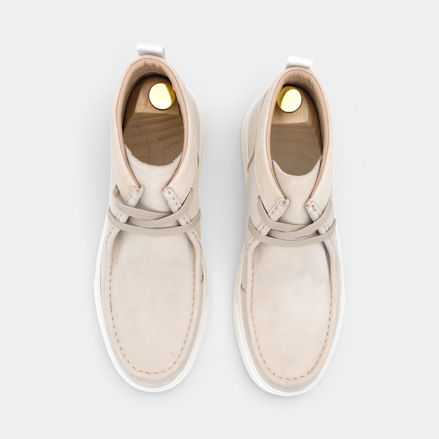 Barcon Getta Inc beige leather chukka boots with white rubber sole and lace-up closure.