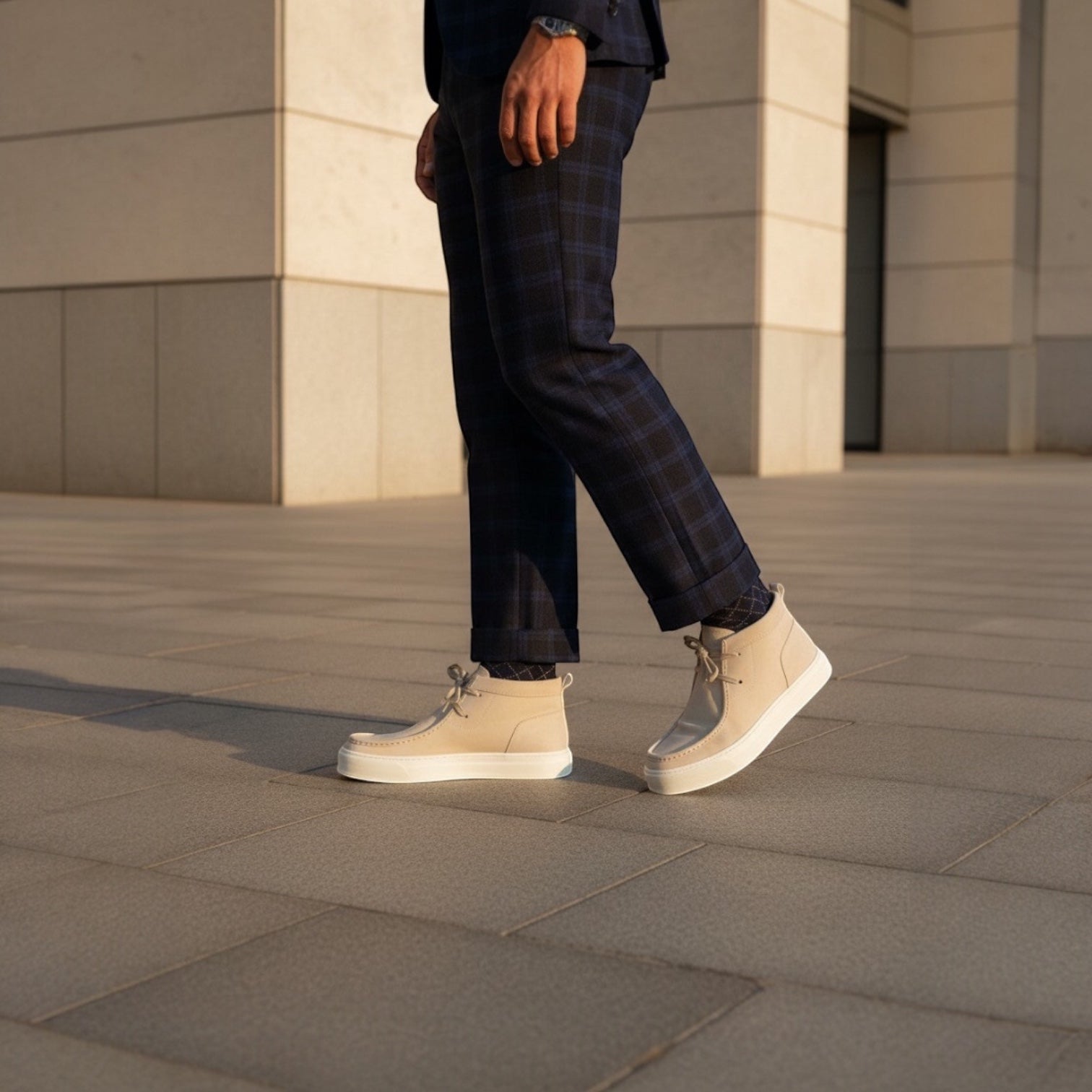 Barcon Getta Inc beige leather chukka boots with white rubber sole and lace-up closure, worn with navy plaid trousers.