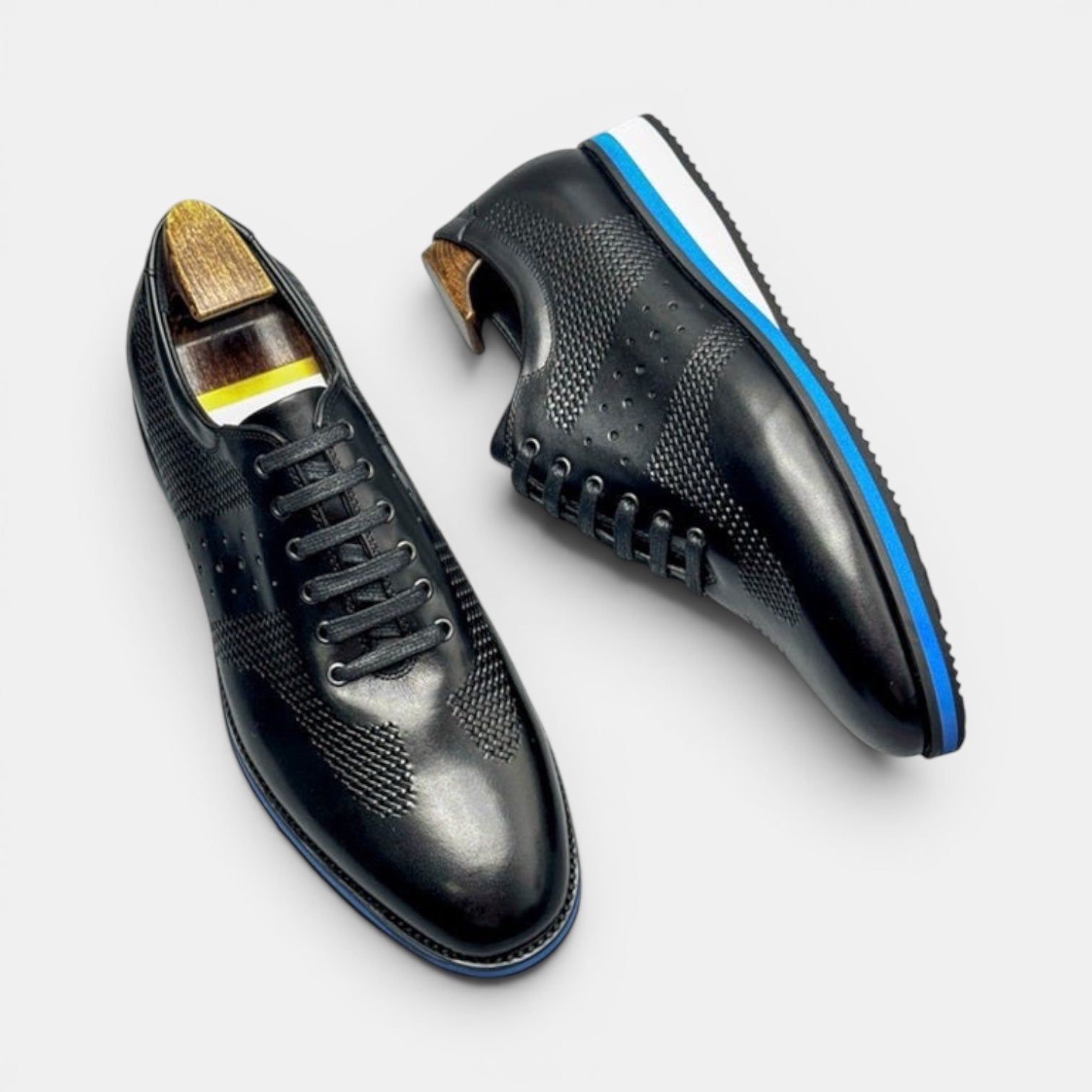 Barcon Getta Inc black full grain leather dress shoes with sneaker sole, perforated details, and blue stripe midsole.