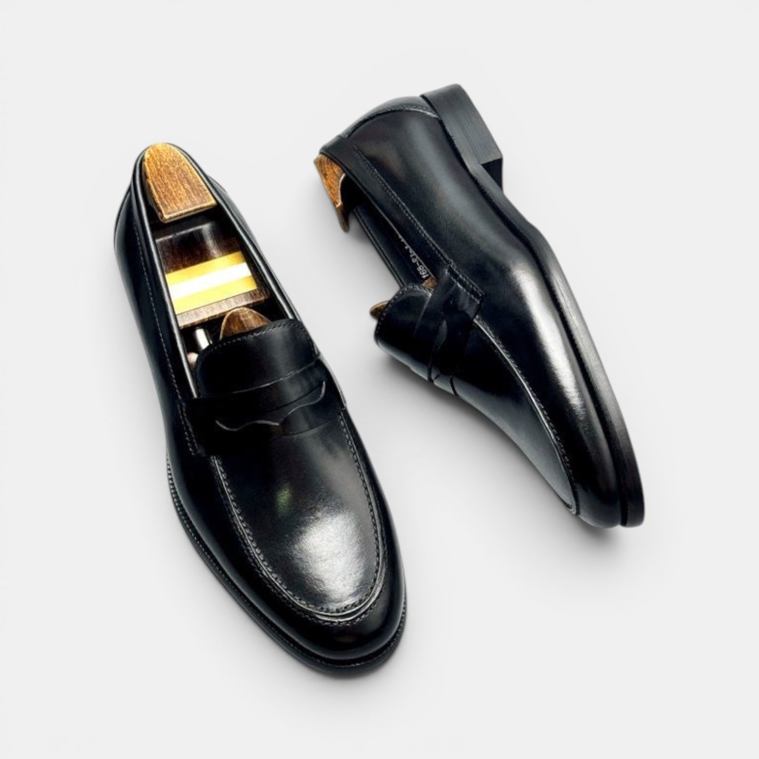 Barcon Getta Inc BANGUI black polished leather penny loafers with classic vamp strap and shoe trees.