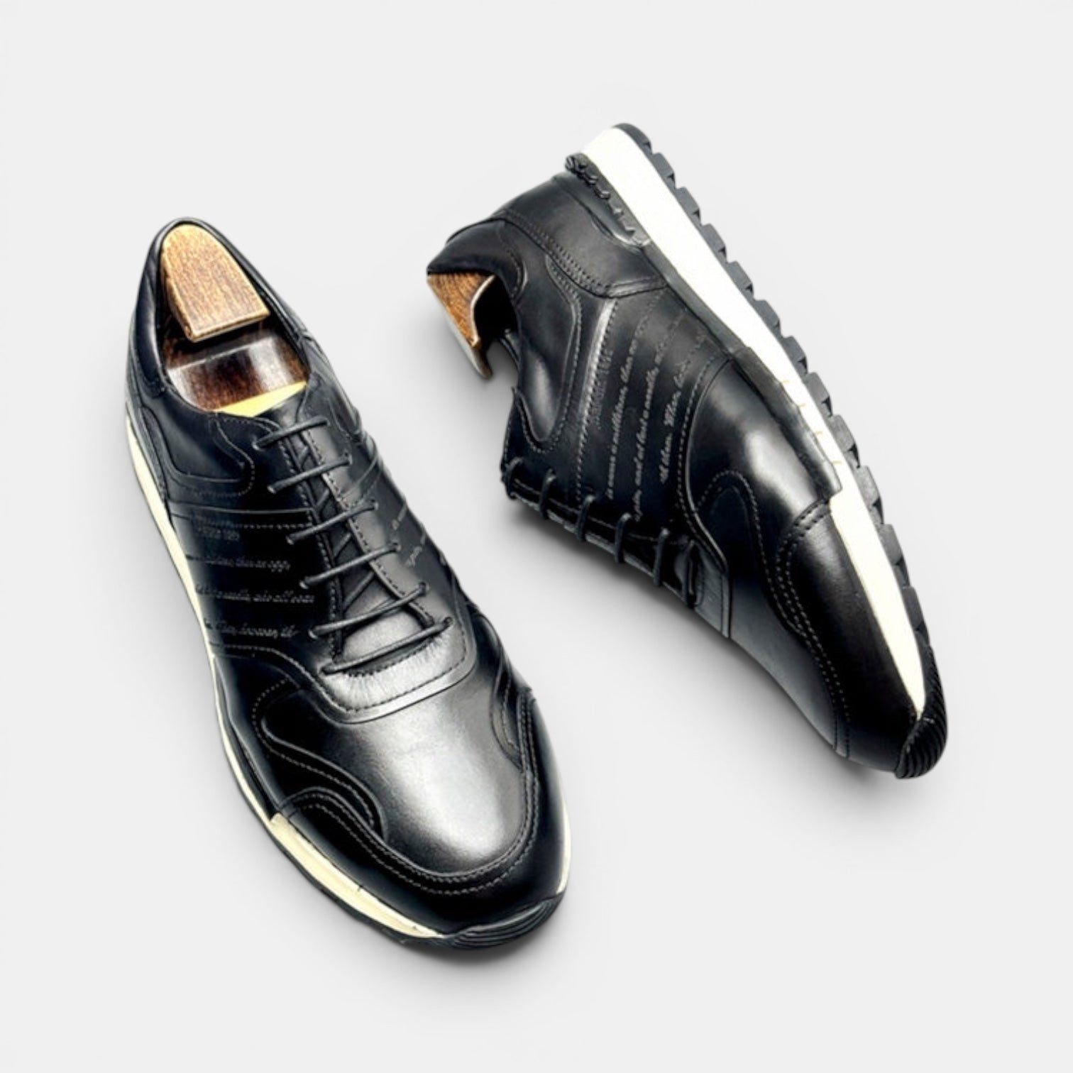 Barcon Getta Inc black full grain leather casual sneakers with cap toe and embossed script on a chunky lug sole.