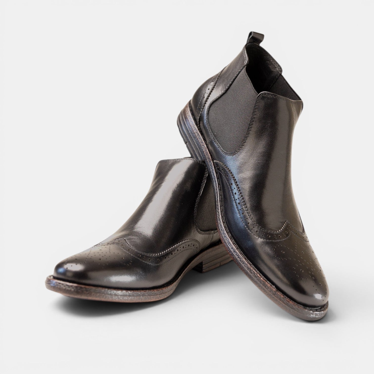 Barcon Getta Inc black leather wingtip Chelsea boots with brogue perforations and elasticated side panels.