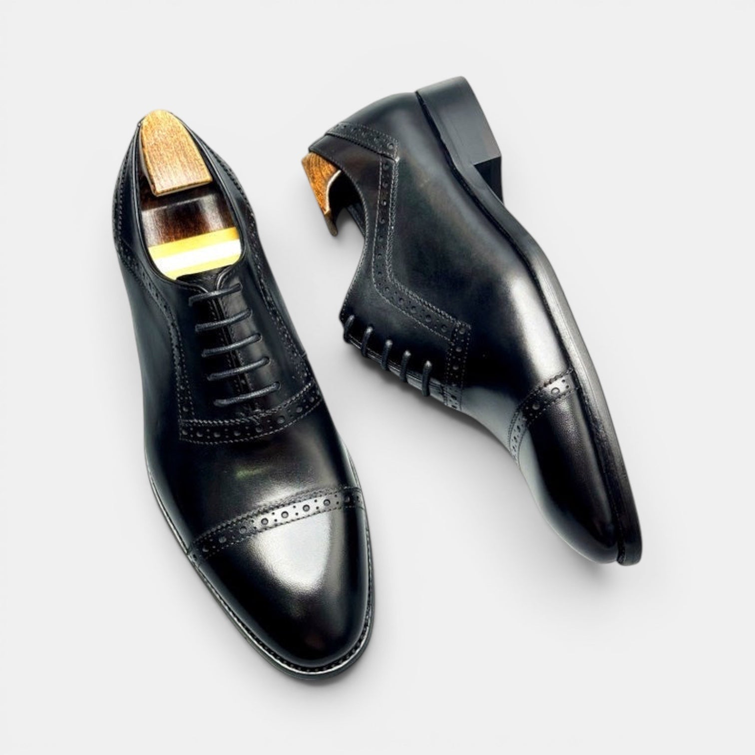 Barcon Getta Inc black full grain leather cap toe Oxford dress shoes with brogue detailing and hybrid sole.