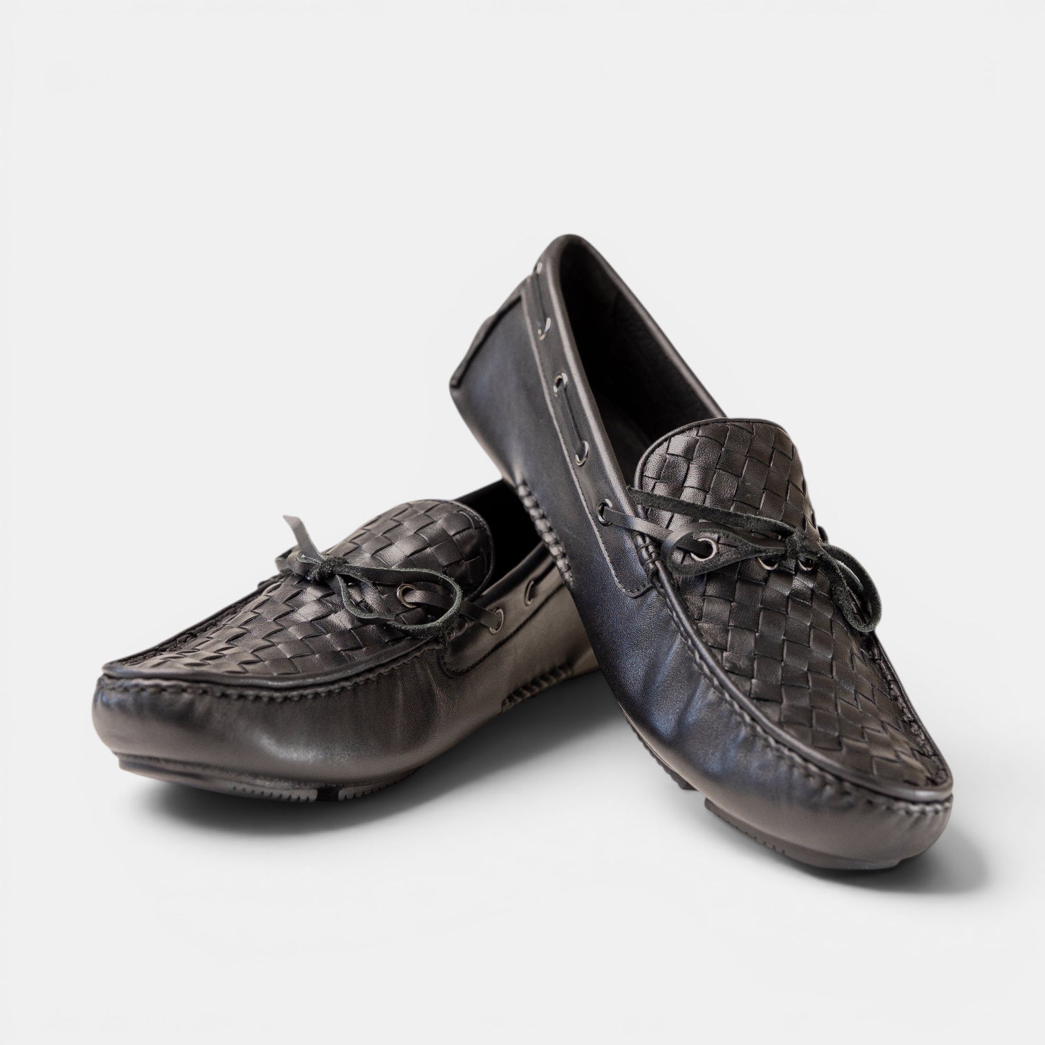 Barcon Getta Inc black woven leather driving moccasins with bow detail and gunmetal eyelets.