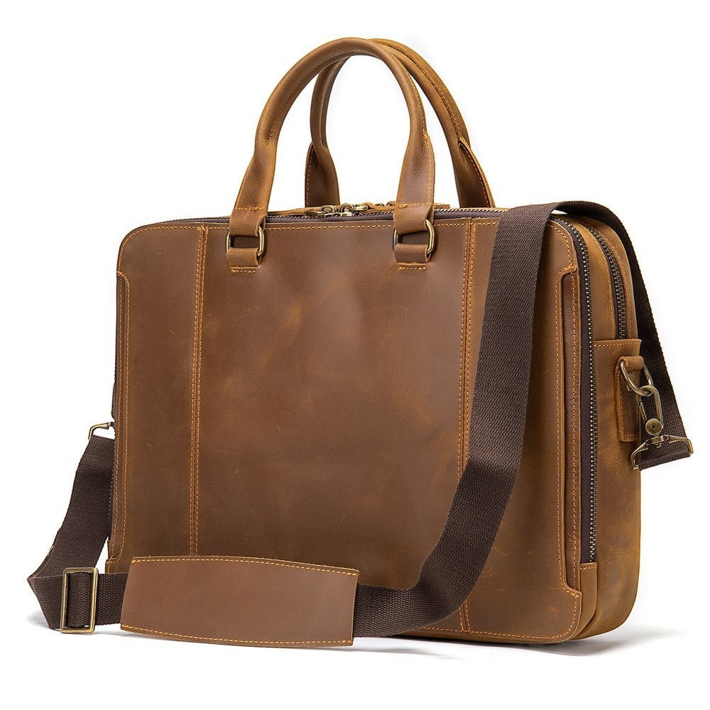 Barcon Getta Inc brown leather briefcase with top handles, adjustable strap, and multiple zipper pockets. Fits up to 17" laptop.