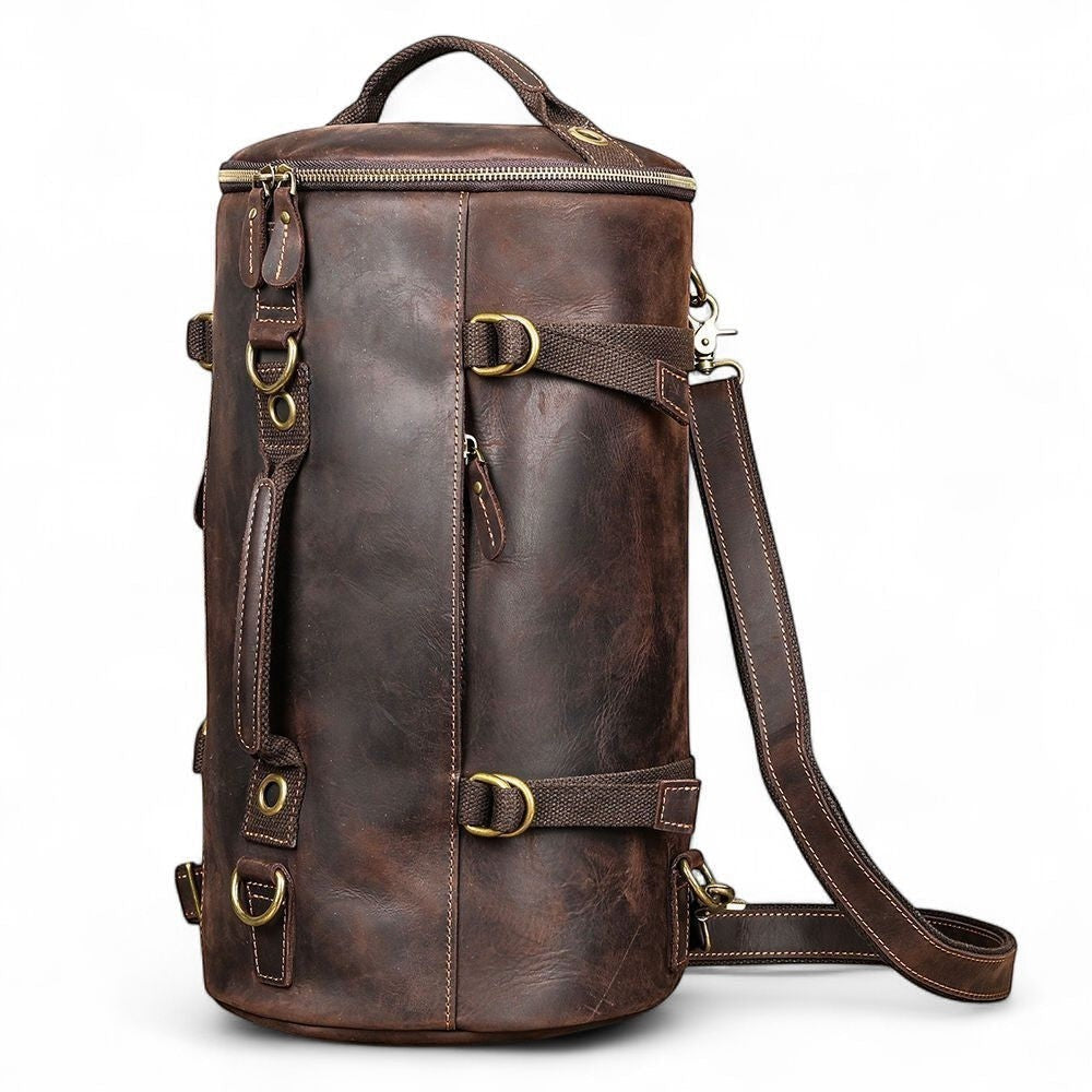 Barcon Getta Inc The Continental 2-1 Duffel, brown distressed genuine leather cylindrical travel bag with brass hardware, top handles, and detachable shoulder strap.