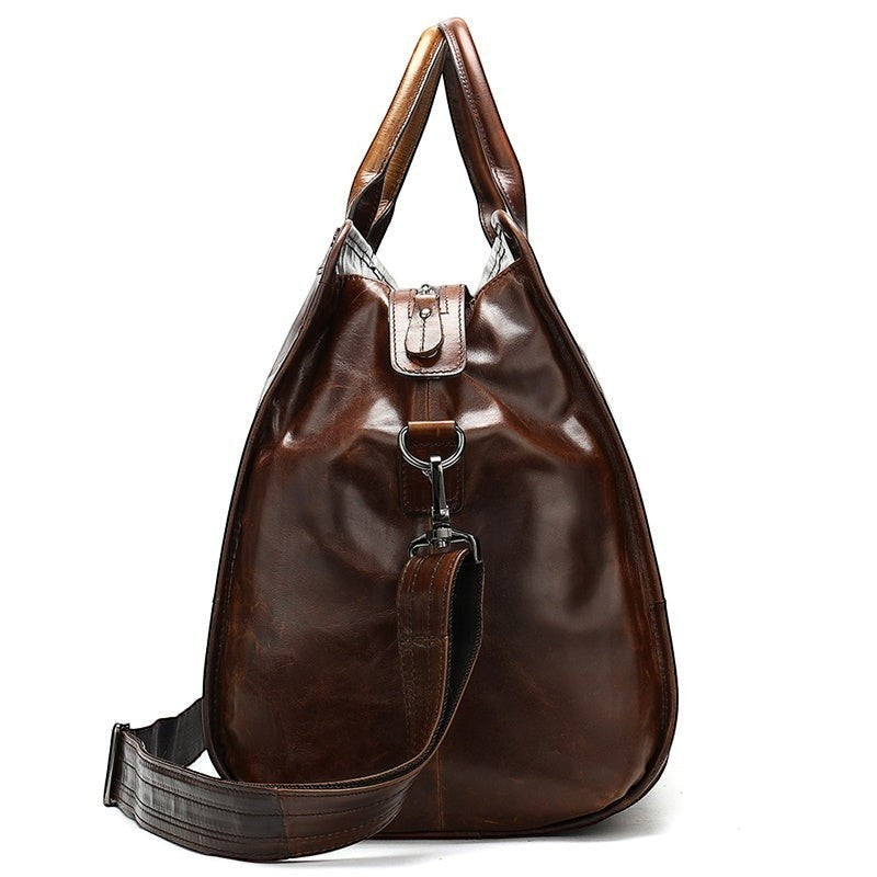 Brown leather handbag with a shoulder strap on a white background