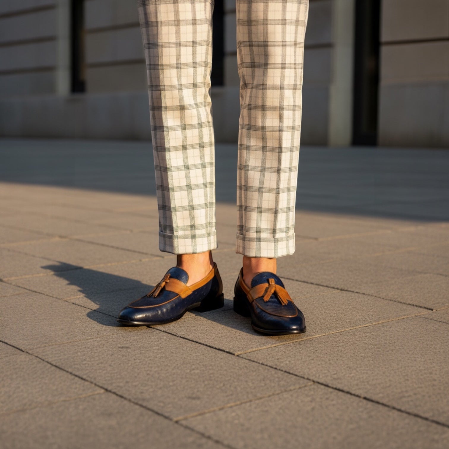 Barcon Getta Inc navy ostrich-embossed leather kiltie tassel loafers with tan trim and a low stacked heel.