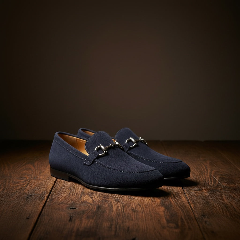 Barcon Getta Inc navy blue suede horsebit loafers with silver-tone hardware on a wooden surface.