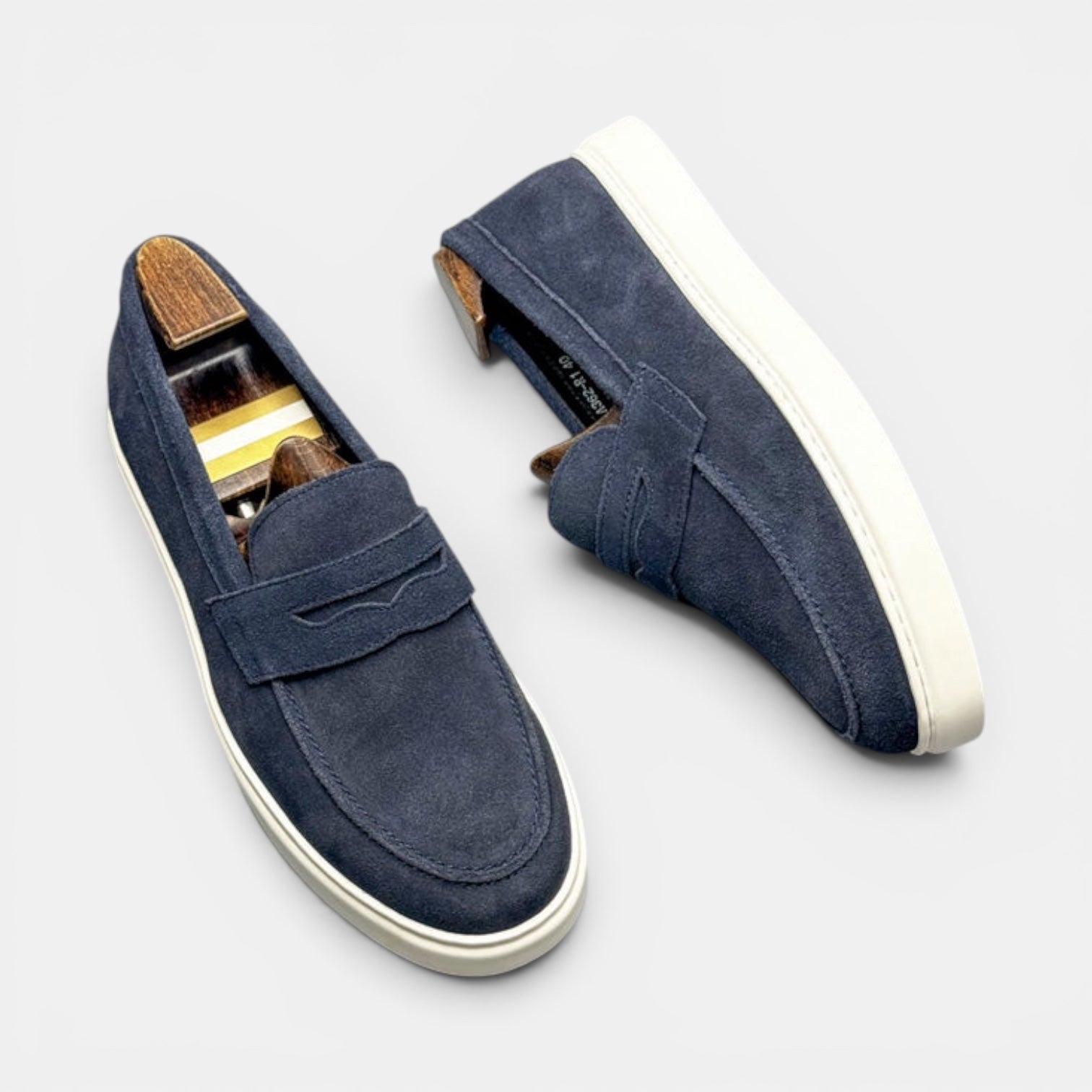 Barcon Getta Inc MEDA navy blue suede penny loafer sneakers with white soles and classic penny slot.