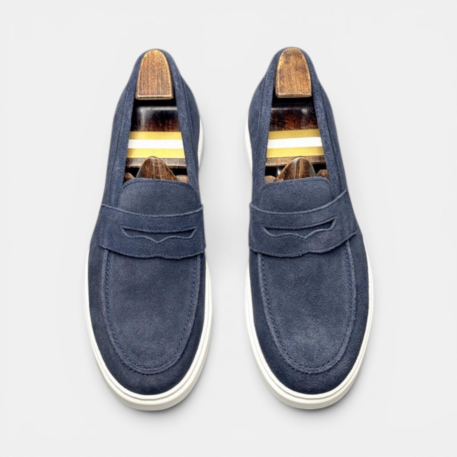 Barcon Getta Inc MEDA navy blue suede penny loafer sneakers with white rubber soles and wooden shoe trees.