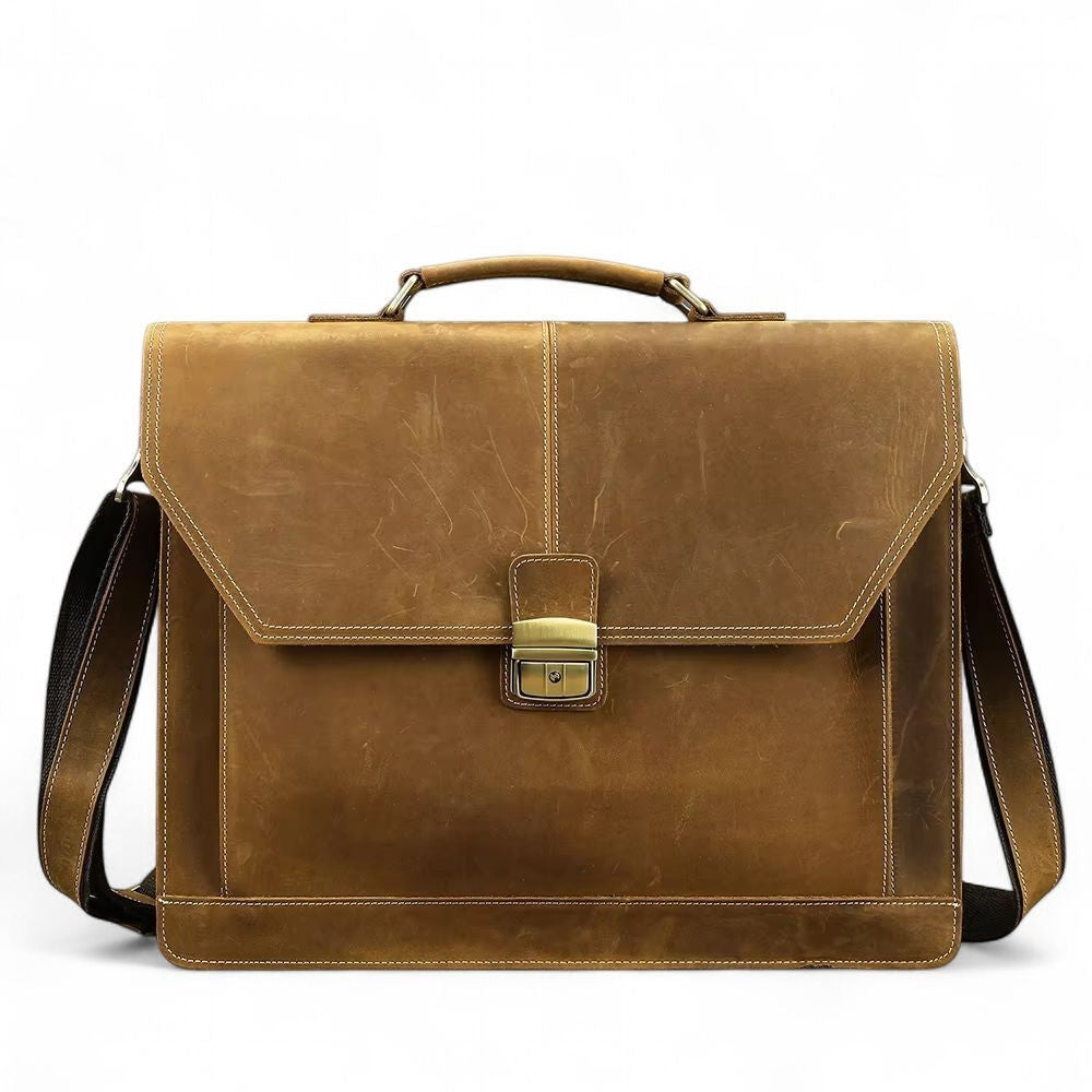 Barcon Getta Inc brown leather briefcase with brass buckle, top handle, and adjustable shoulder strap. Fits up to 16" laptop.