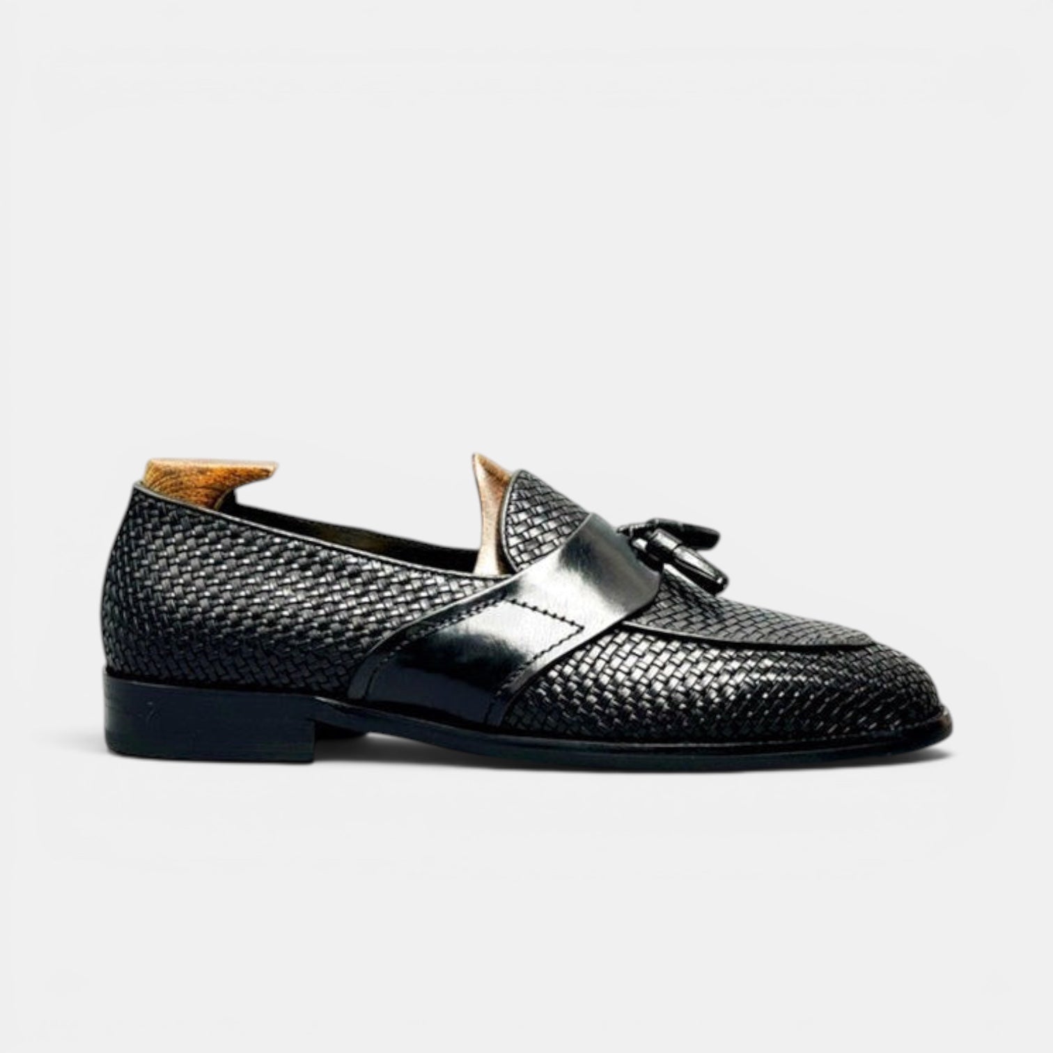 Barcon Getta Inc black woven leather tassel loafers with a patent leather strap and gold accent.