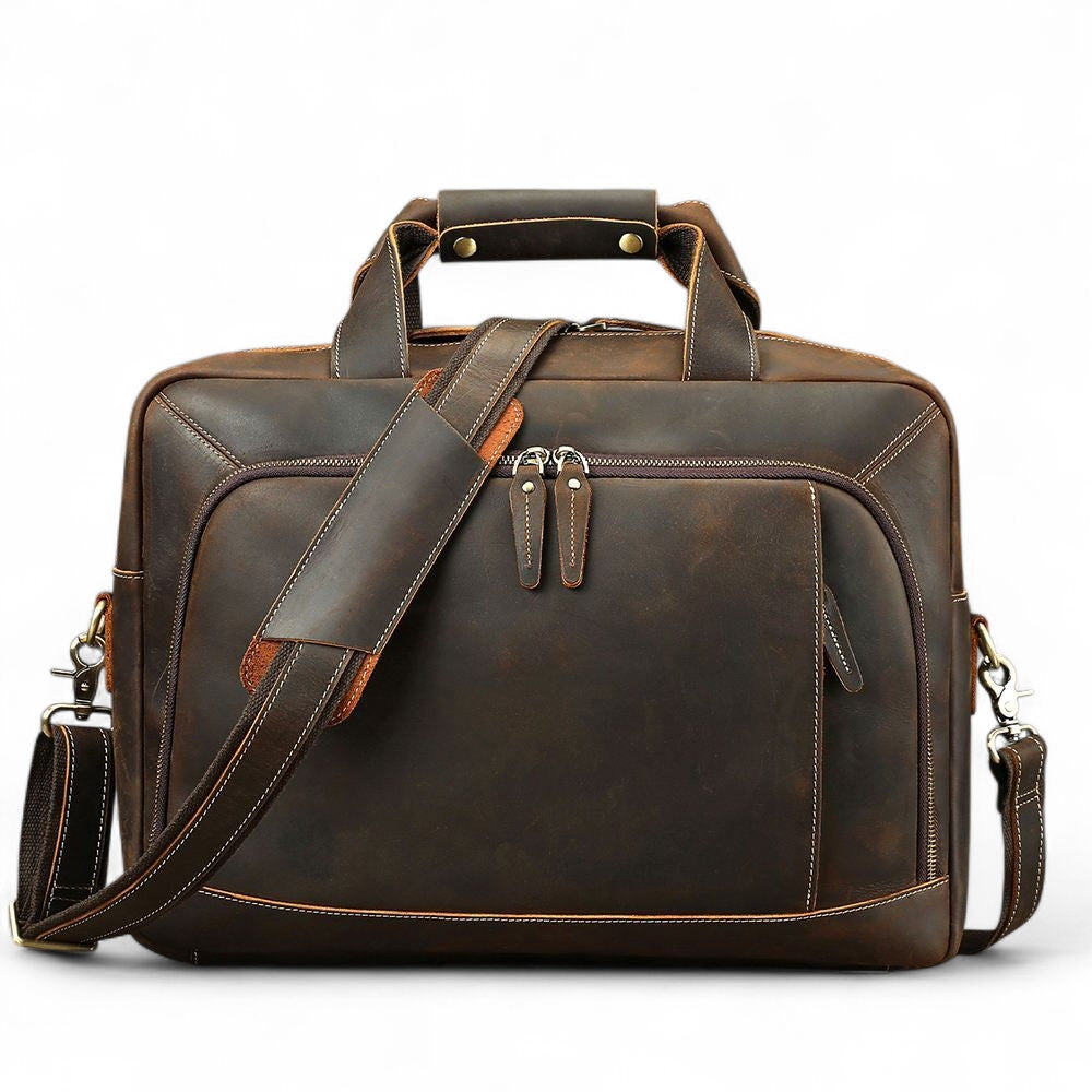 Brown leather briefcase with shoulder strap on a white background